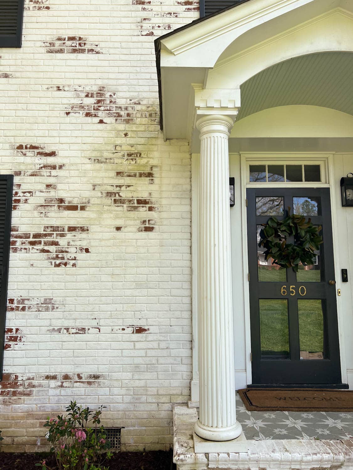 dirty limewashed brick before cleaning beside a porch stoop