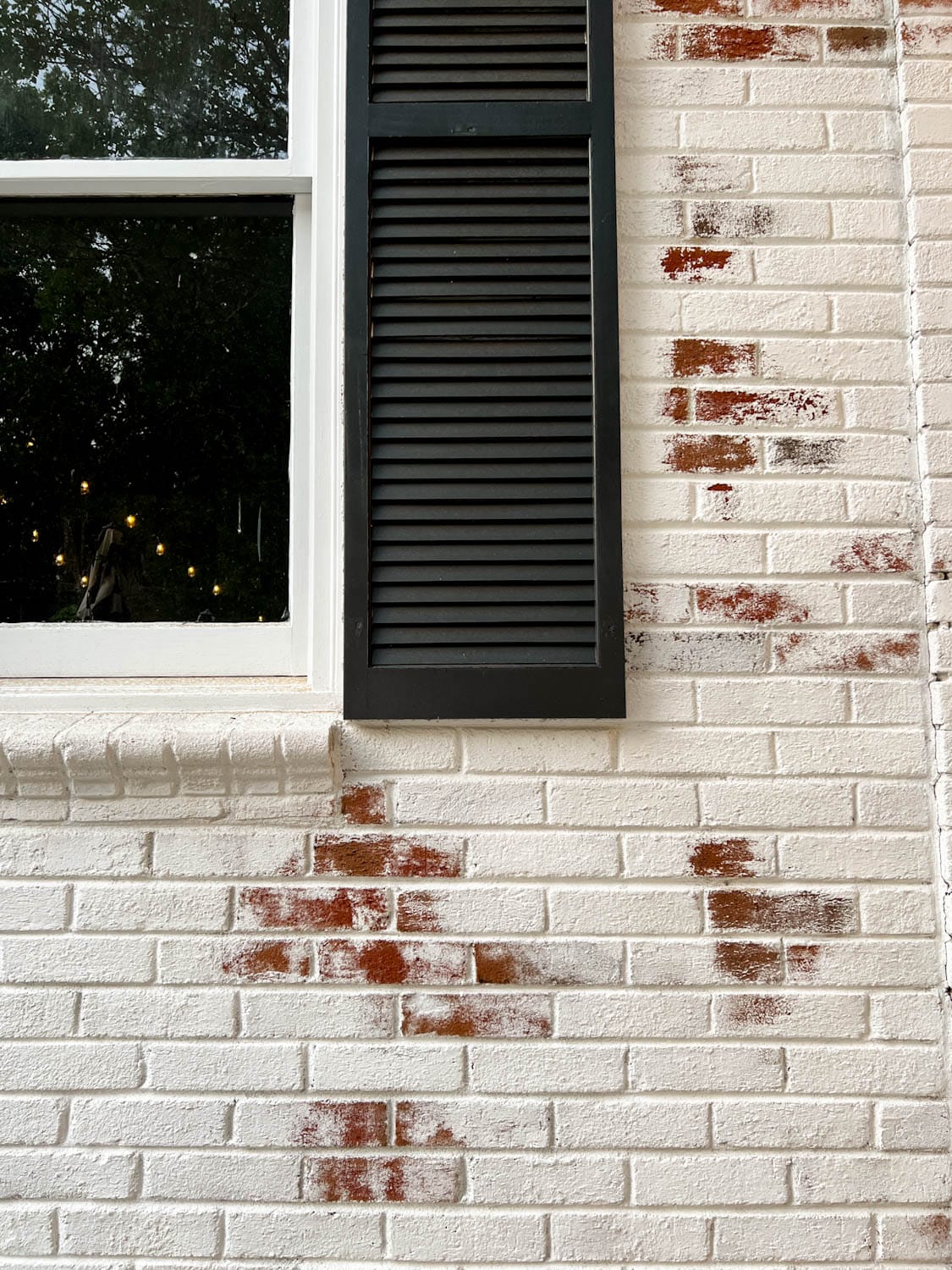 white limewashed brick and black shutters