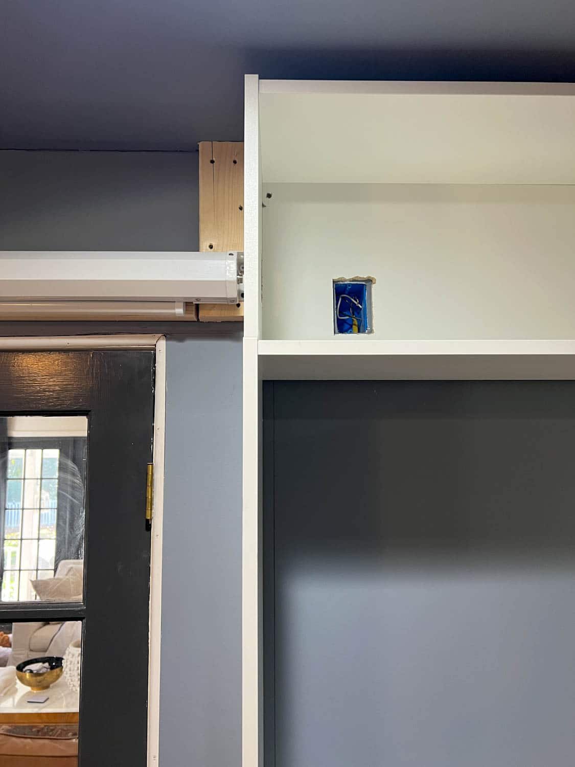 cutting out outlet access with jigsaw in bookcase