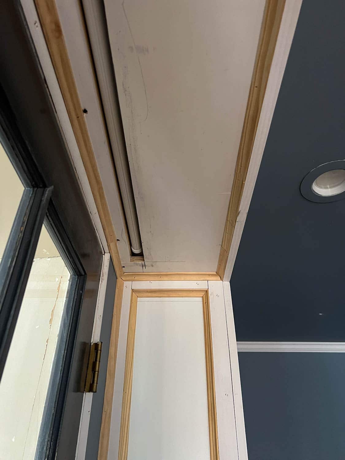 hidden projector screen box between bookcases above french doors