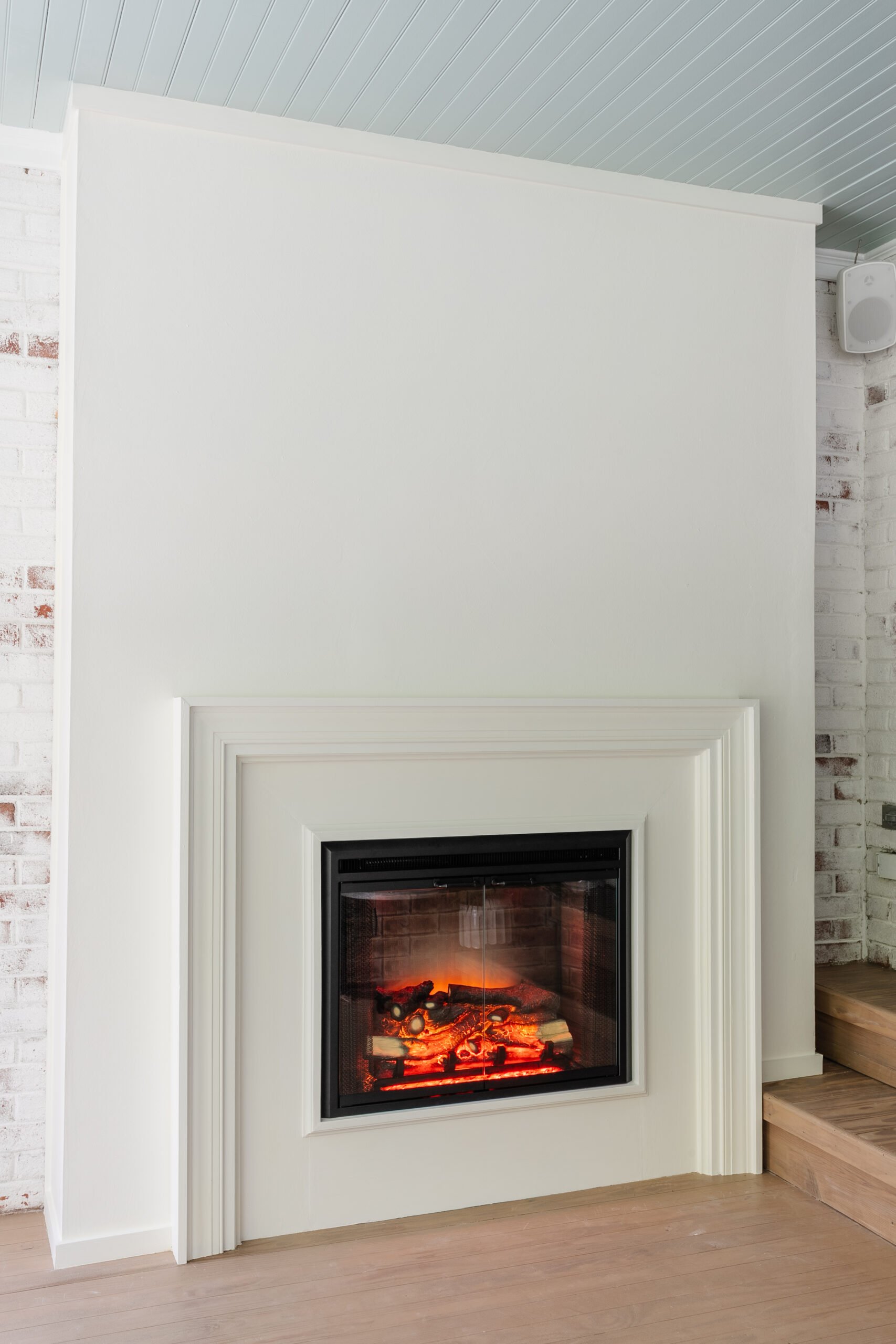 finished plaster fireplace with electric insert and limewashed brick