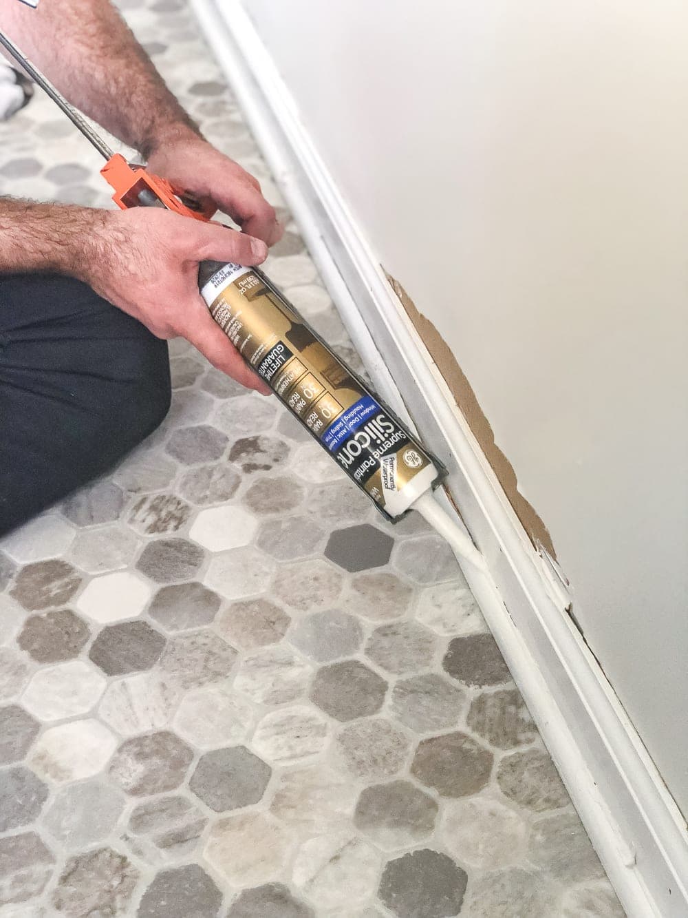 applying silicone caulk on moulding