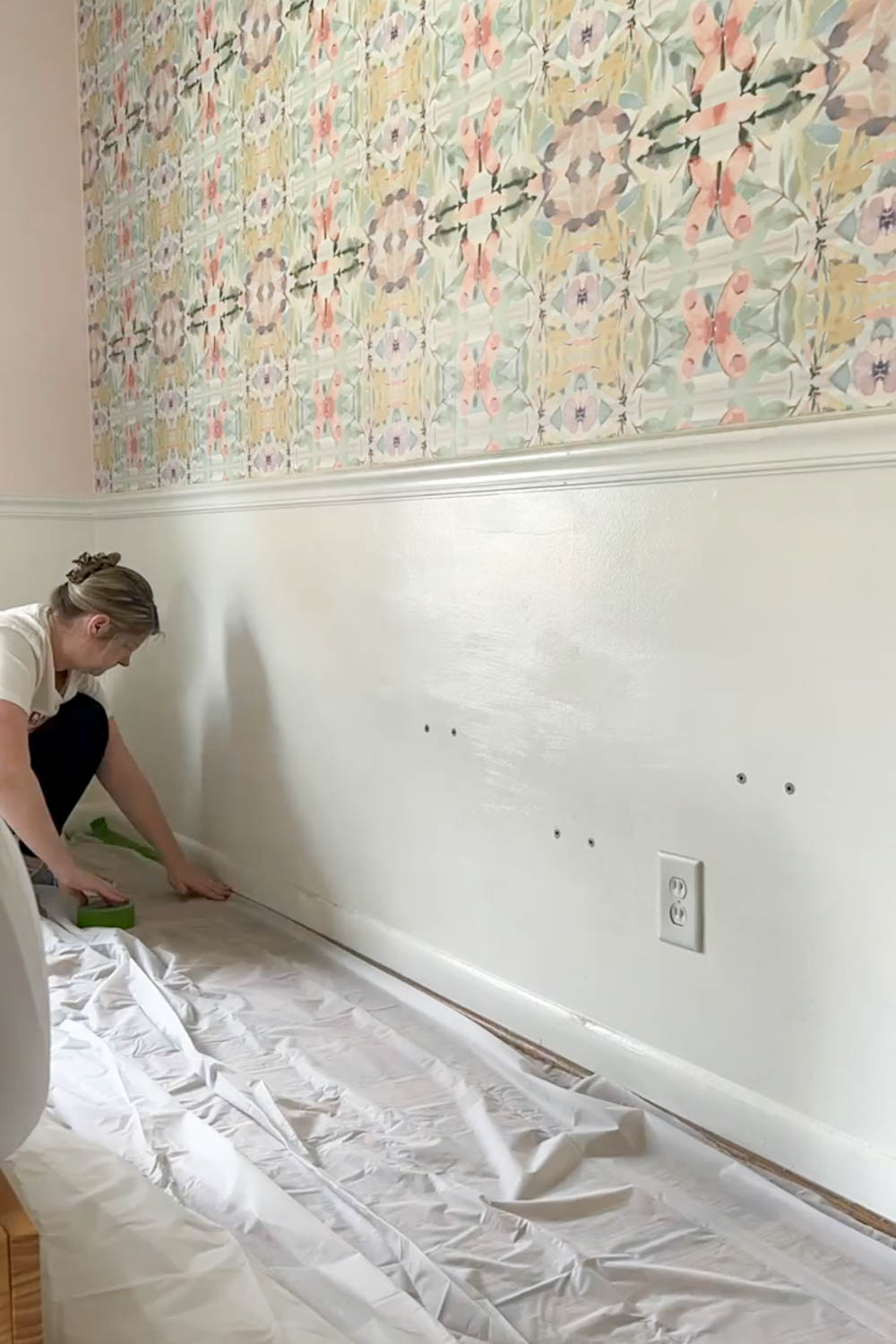 putting down drop cloth to protect floors from wallpaper removal