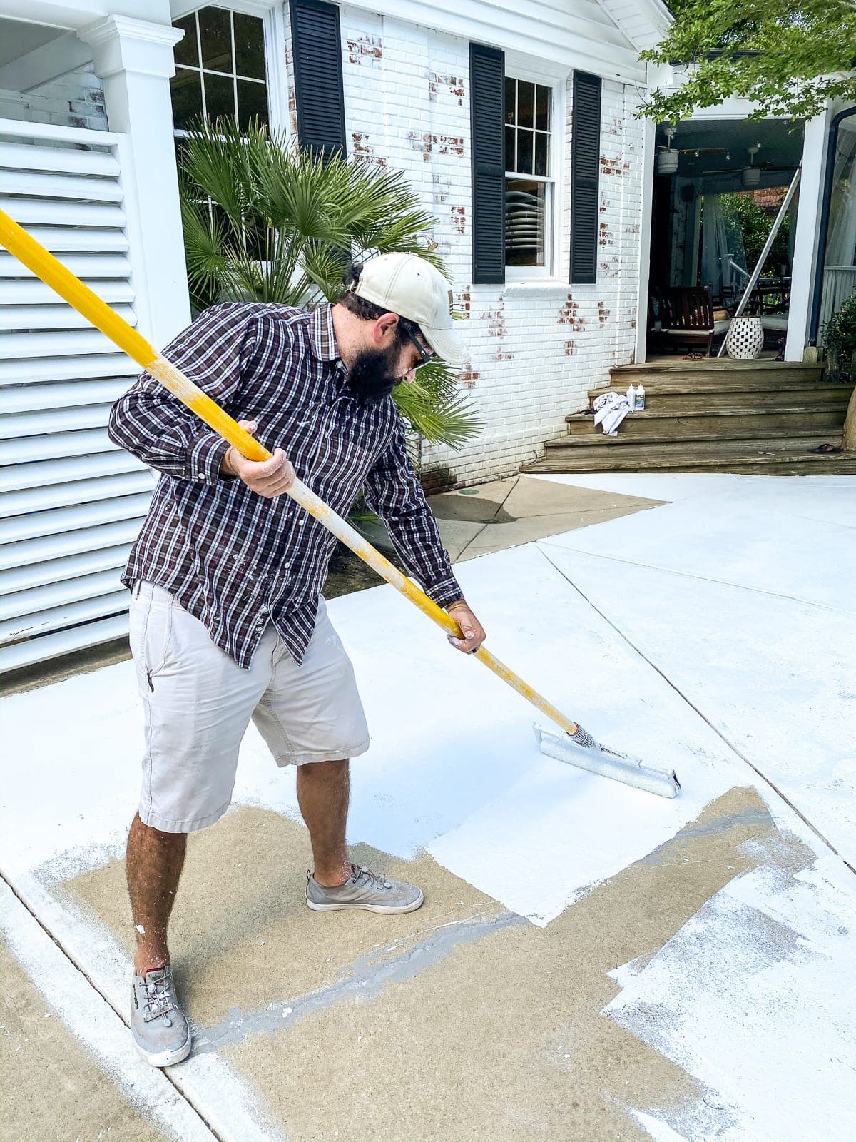 rolling on exterior primer before painting a concrete patio and pool deck
