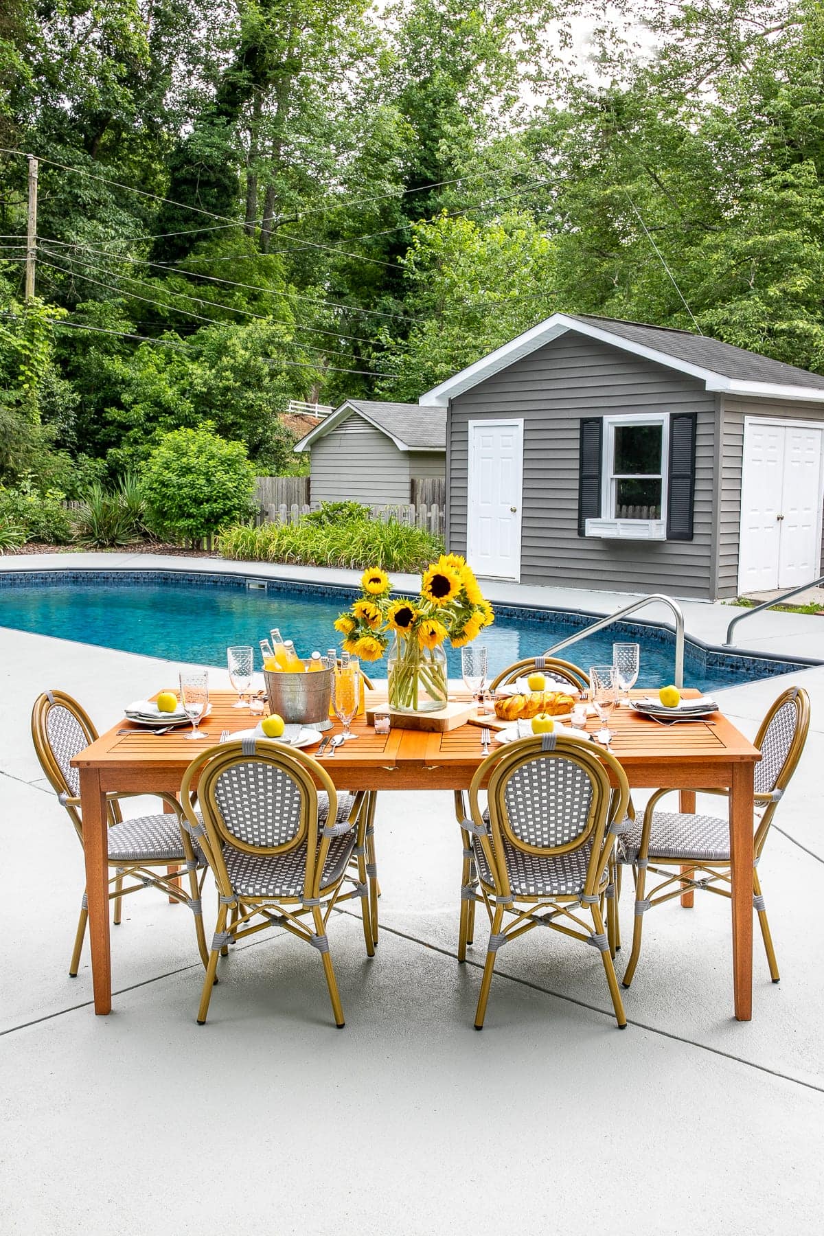 concrete pool deck with patio dining table and chairs