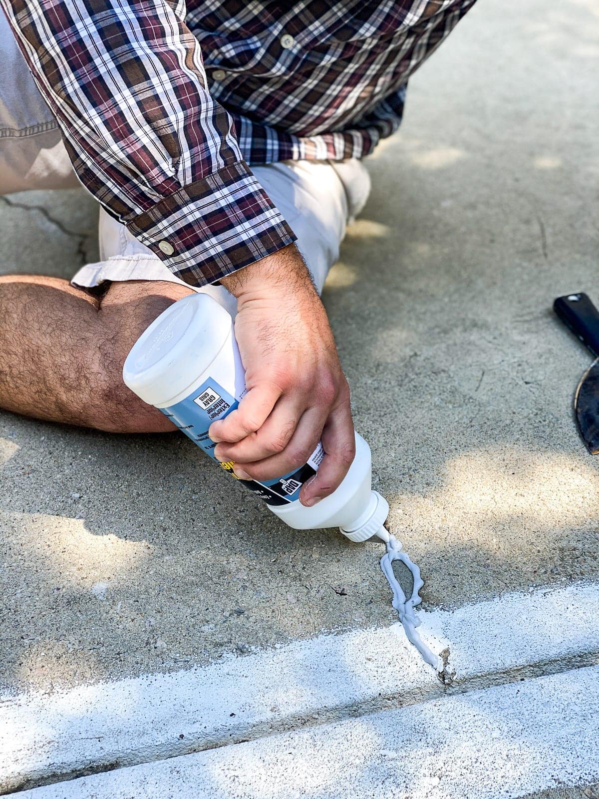 applying concrete filler to fill cracks and holes before painting